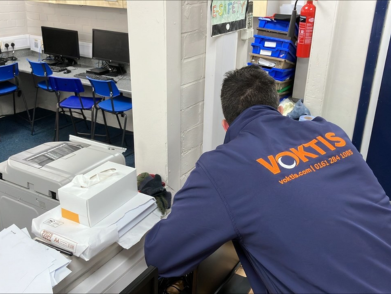 Employee wearing Voktis uniform working in office workspace.